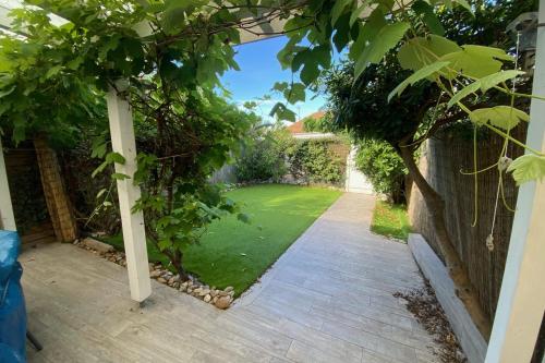 un jardin avec une pergola et une pelouse dans l'établissement A stone's throw from the sea!, à Frontignan