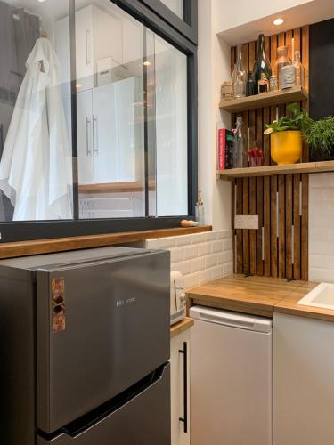 Il comprend une cuisine équipée d'un réfrigérateur en acier inoxydable et une fenêtre. dans l'établissement La Terrasse, à Arras