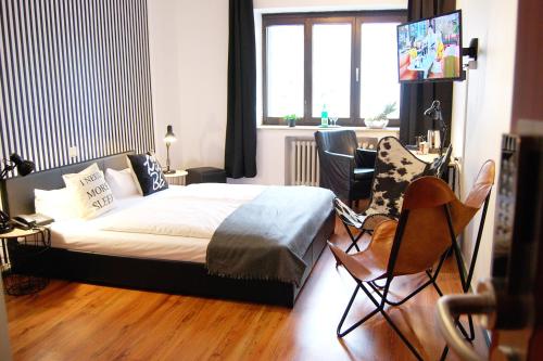 um quarto com uma cama e cadeiras num quarto em Hotel Alt Deutz City-Messe-Arena KONTAKTLOSER SELF CHECK-IN em Colônia