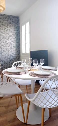 - une table et des chaises blanches avec des verres à vin dans l'établissement Le Grain de Sable, à Royan