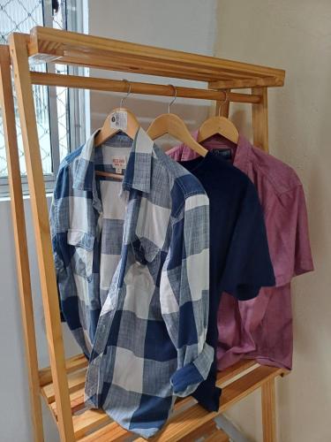 a rack of shirts on hangers in a room at Hospede-se no IPSEP , em Recife , próximo ao Aeroporto Internacional dos Guararapes in Recife