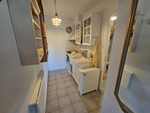 Il comprend une cuisine avec des placards blancs et du carrelage. dans l'établissement 5 couchages, vue mer, climatisation, WIFI, tout à pied, plage à 250m, à La Seyne-sur-Mer