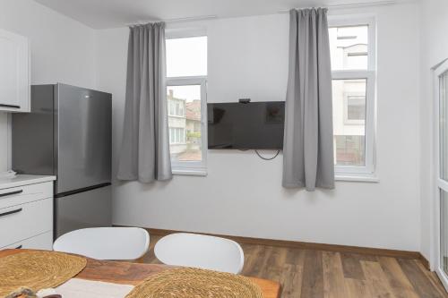 a kitchen with a table and chairs and two windows at The Central House 1 in Burgas City