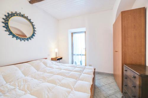 a large white bed in a room with a mirror at Perfume House in Marciana