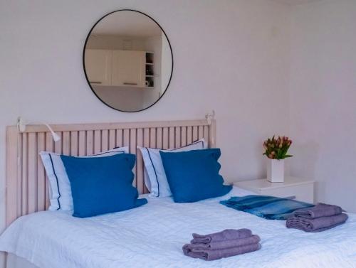 a bedroom with a bed with blue pillows and a mirror at Lovely studio in the citycenter of Sigtuna in Sigtuna