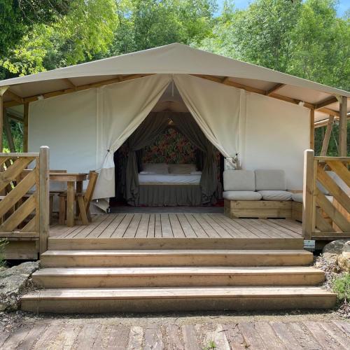 a tent with a bed and a table and stairs at Agriturismo Fontenuova in Saturnia