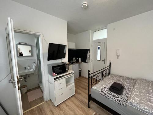 una piccola camera con letto e televisore di KnocksCasa4You Mini Appartement Nr 22 a Marburg an der Lahn
