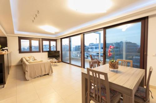 un soggiorno con tavolo da pranzo e una grande finestra di Cityscape Loft a Città di Rodi