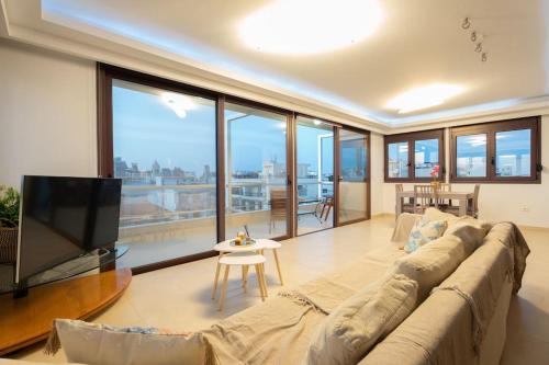 un soggiorno con un grande divano e una TV a schermo piatto di Cityscape Loft a Città di Rodi