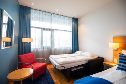 a room with a bed and a chair and a window at Quality Hotel Ulstein in Ulsteinvik