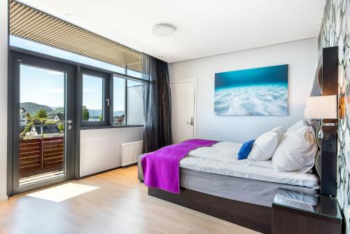 a bedroom with a bed and a large window at Quality Hotel Ulstein in Ulsteinvik