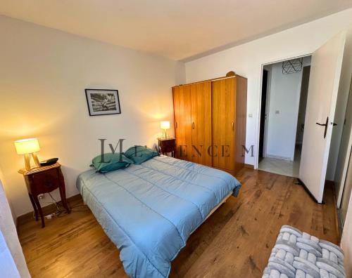 - une chambre avec un grand lit et une armoire en bois dans l'établissement Appartement San Francescu centre-ville CALVI, à Calvi