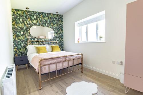 a bedroom with a bed with yellow pillows and a mirror at The Tractor Shed at Richborough Farm in Sandwich