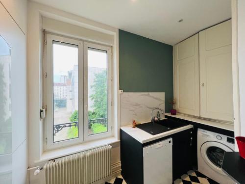 une cuisine avec un évier et une fenêtre dans l'établissement Le Poincaré! - Appartement T3, à Nancy
