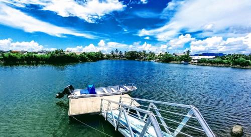 ein Boot, das mit einem Dock an einem Fluss verbunden ist in der Unterkunft Waterfront Sunset Apartment in Fantasy Island Nadi in Nadi