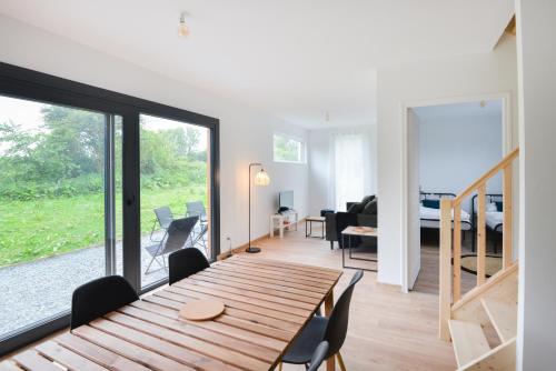- une salle à manger et un salon avec une table en bois dans l'établissement Le Normandy - Sauna - A moins de 2 km de la plage, à Sainte-Honorine-des-Pertes