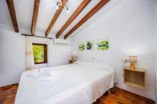1 dormitorio con cama blanca y ventana en Villa Piedra, en Pollensa