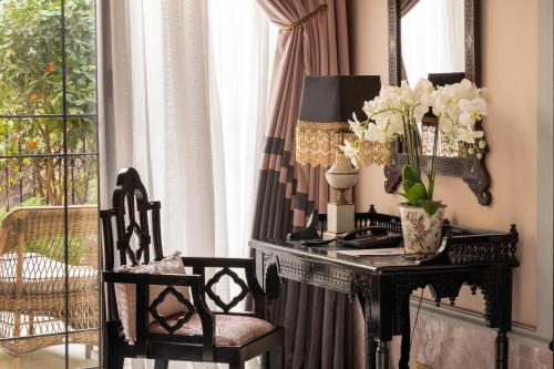 a room with a table with a vase of flowers on it at Palais Ronsard Relais & Chateaux in Marrakech