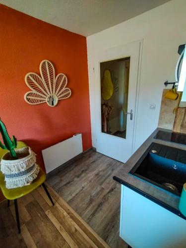 - une cuisine avec un mur orange et un évier dans l'établissement Le fringant, à Avignon