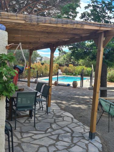 une pergola en bois avec des chaises, une table et une piscine dans l'établissement Maison proche mer Saint raphael, à Saint-Raphaël