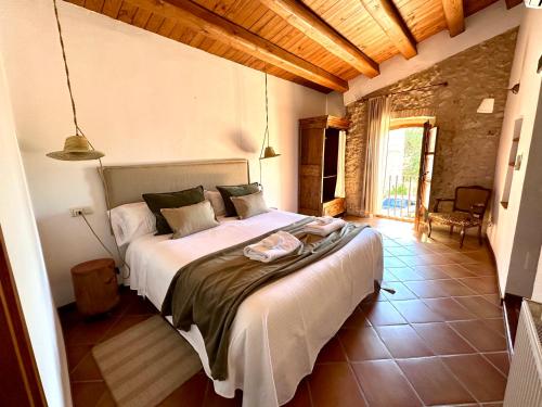 una camera con un grande letto di Mas Camins ad Avinyonet de Puigventós