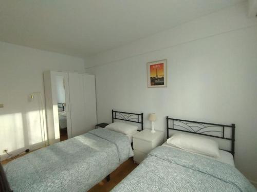 une chambre avec trois lits et un miroir dans l'établissement 5 mn, 450m walk Metro La Defense, 3 bedrooms, Parking, à Puteaux