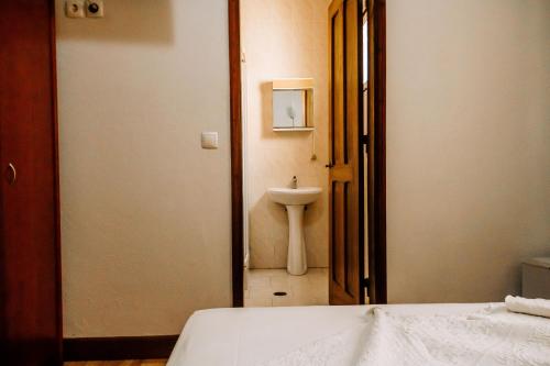 圣多美Hotel Agosto Neto的房间里有带水槽的浴室和一张床