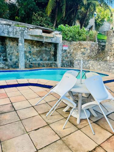 a table and two chairs next to a swimming pool at Casa na praia in Arraial do Cabo