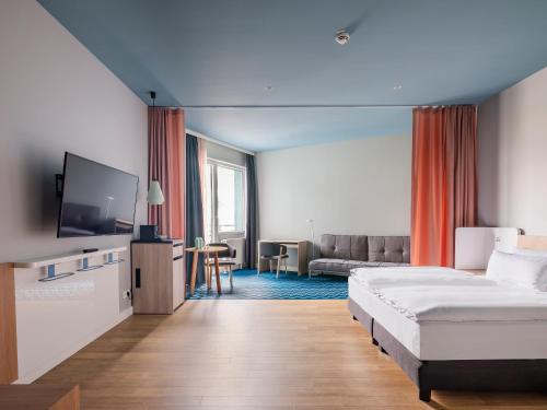 um quarto de hotel com uma cama e um sofá em Numa Berlin Kudamm em Berlim