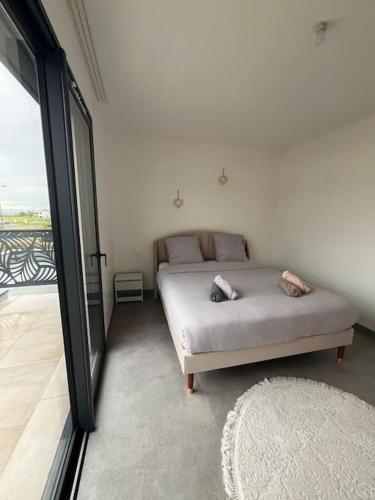 une chambre avec un lit et une grande fenêtre dans l'établissement Villa à Cébazat, à Cébazat