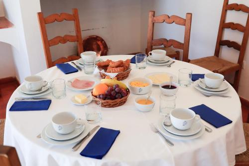 a white table with a bowl of fruit on it at Monte de Bordalos in Monte de Bordalos