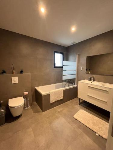 une salle de bain avec une baignoire, des toilettes et un lavabo dans l'établissement Villa à Cébazat, à Cébazat