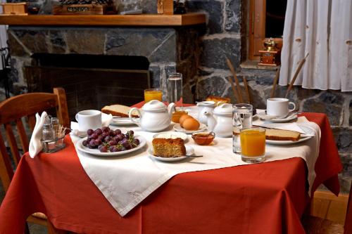 a table with a breakfast of fruit and biscuits and orange juice at Hotel Semeli in Goura