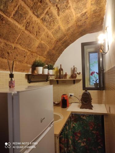 una cucina con frigorifero bianco e soffitto in legno di Il Tufo D'amare appartamento affitti brevi a Rutigliano