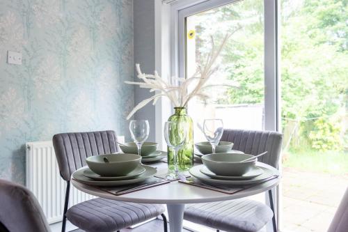 a dining room table with chairs and a vase at Croftspar House in Glasgow
