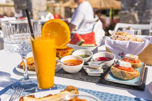 a table with a tray of food and a glass of orange juice at Naxos Cave Suites in Stelida