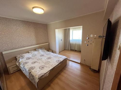 een kleine slaapkamer met een bed en een raam bij Apartament in Ploieşti
