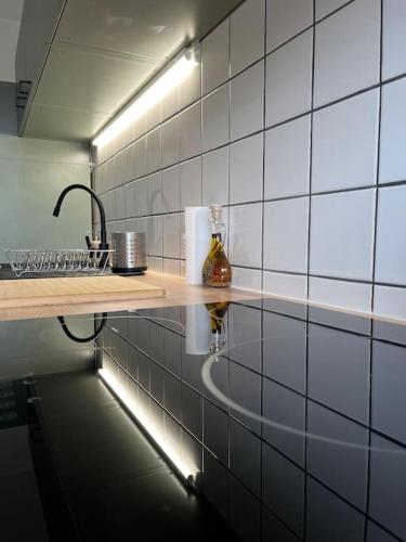 La salle de bains est pourvue d'un comptoir avec un lavabo et une lampe. dans l'établissement Paisible T2, à Villeurbanne