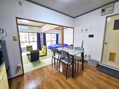 a dining room with a table and chairs and a bedroom at ZEUS choice FUKUOKA in Fukuoka