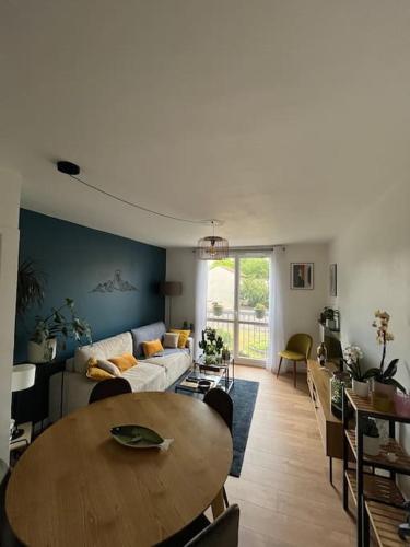 un salon avec une table et un canapé dans l'établissement Paisible T2, à Villeurbanne