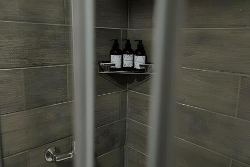 three bottles of wine sitting on a shelf in a shower at Aunaisin - Nona Kate in Ushuaia