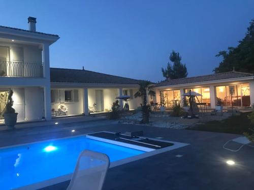 une maison avec piscine la nuit dans l'établissement Les Fontenelliers luxury 5 star villa, à Le Pizou
