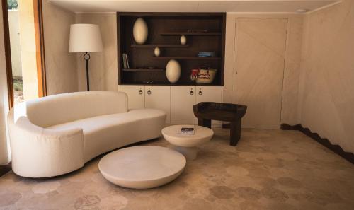 ein Wohnzimmer mit einem weißen Sofa und einem Stuhl in der Unterkunft Boutique Hôtel Responsable et Restaurant Basgi Basgi, ouverture mai 2024 in Saint-Florent