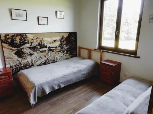 um quarto com duas camas e um quadro na parede em Chata gościom rada em Ustrzyki Dolne