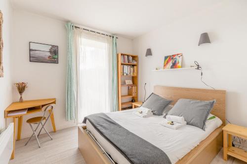 1 dormitorio con cama, escritorio y ventana en GuestReady - Sunlit stay near Père-Lachaise, en París