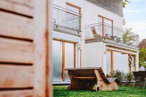 a house with a wooden bench in the yard at Lindenhaus in Zwiesel