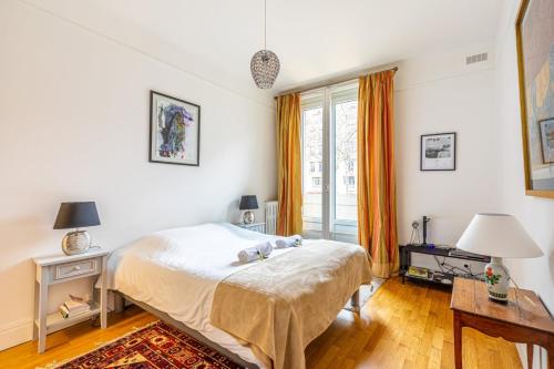 une chambre avec un lit et une grande fenêtre dans l'établissement GuestReady - A humble home in Auteuil, à Paris
