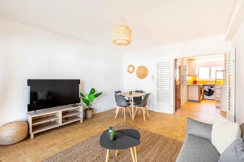 een woonkamer met een tv en een tafel bij GuestReady - Charming living near Paris in Aubervilliers