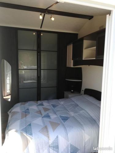 une chambre avec un lit avec une couette bleue et blanche dans l'établissement Mobilhome dans camping Site de Gorge Vent à Fréjus, à Fréjus