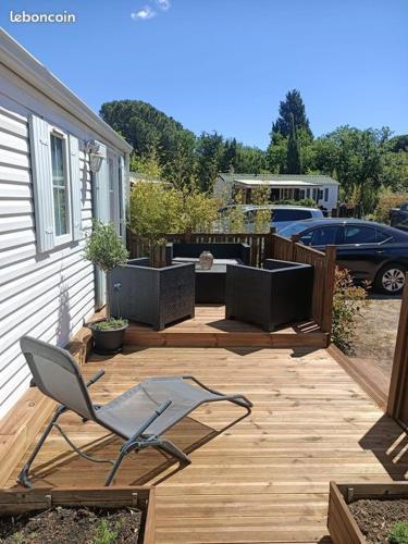 d'un patio avec une chaise sur une terrasse en bois. dans l'établissement Mobilhome dans camping Site de Gorge Vent à Fréjus, à Fréjus